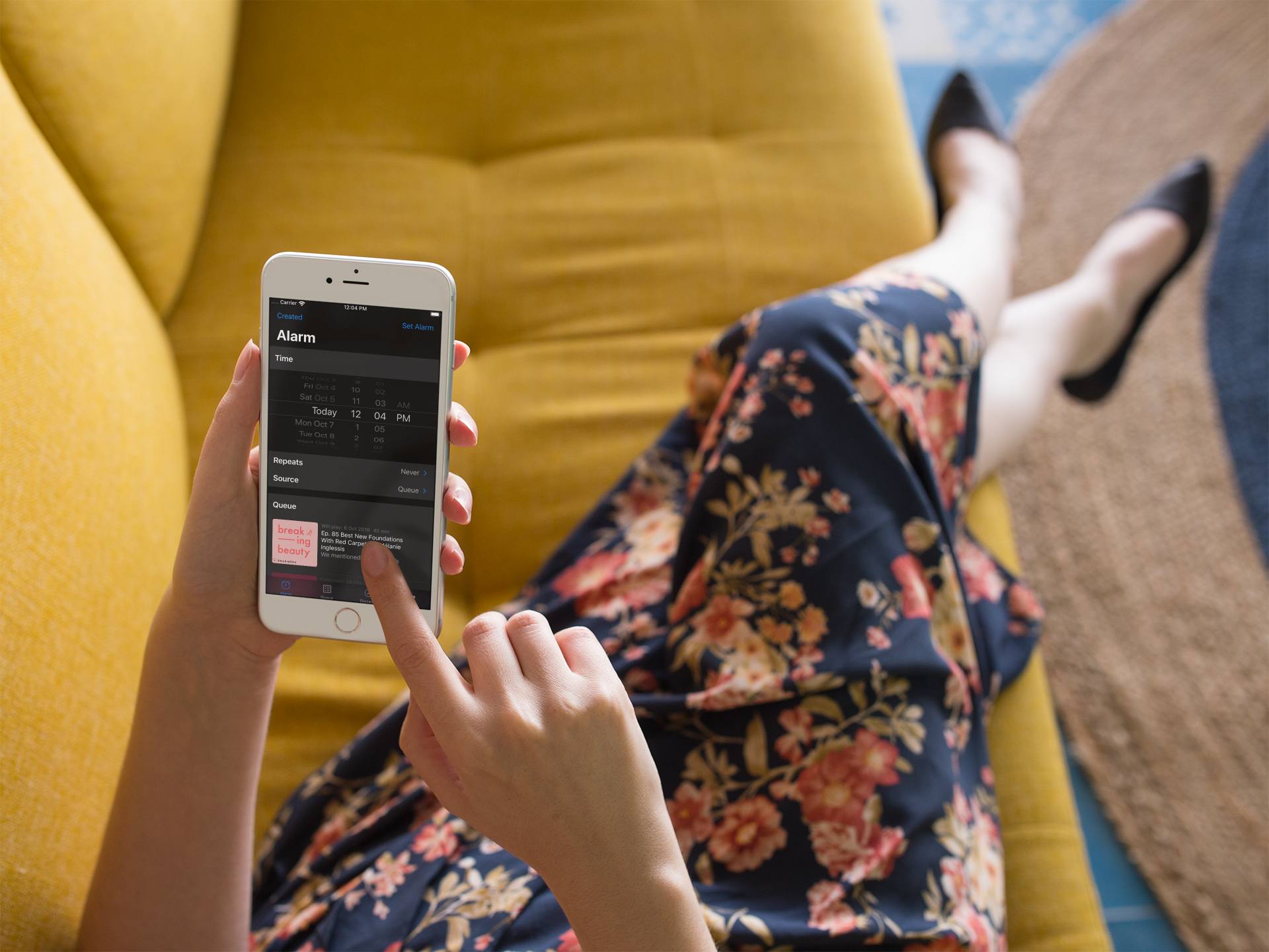 Woman holding an iPhone 8 with the PA set alarm screen visible