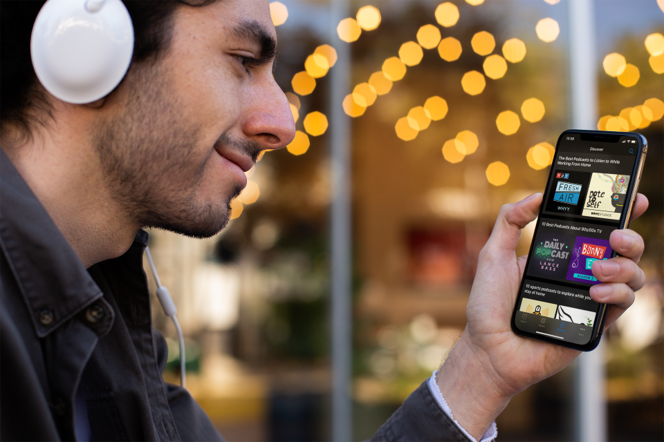 Man looking at the Podcast Alarm discover view with headphones on